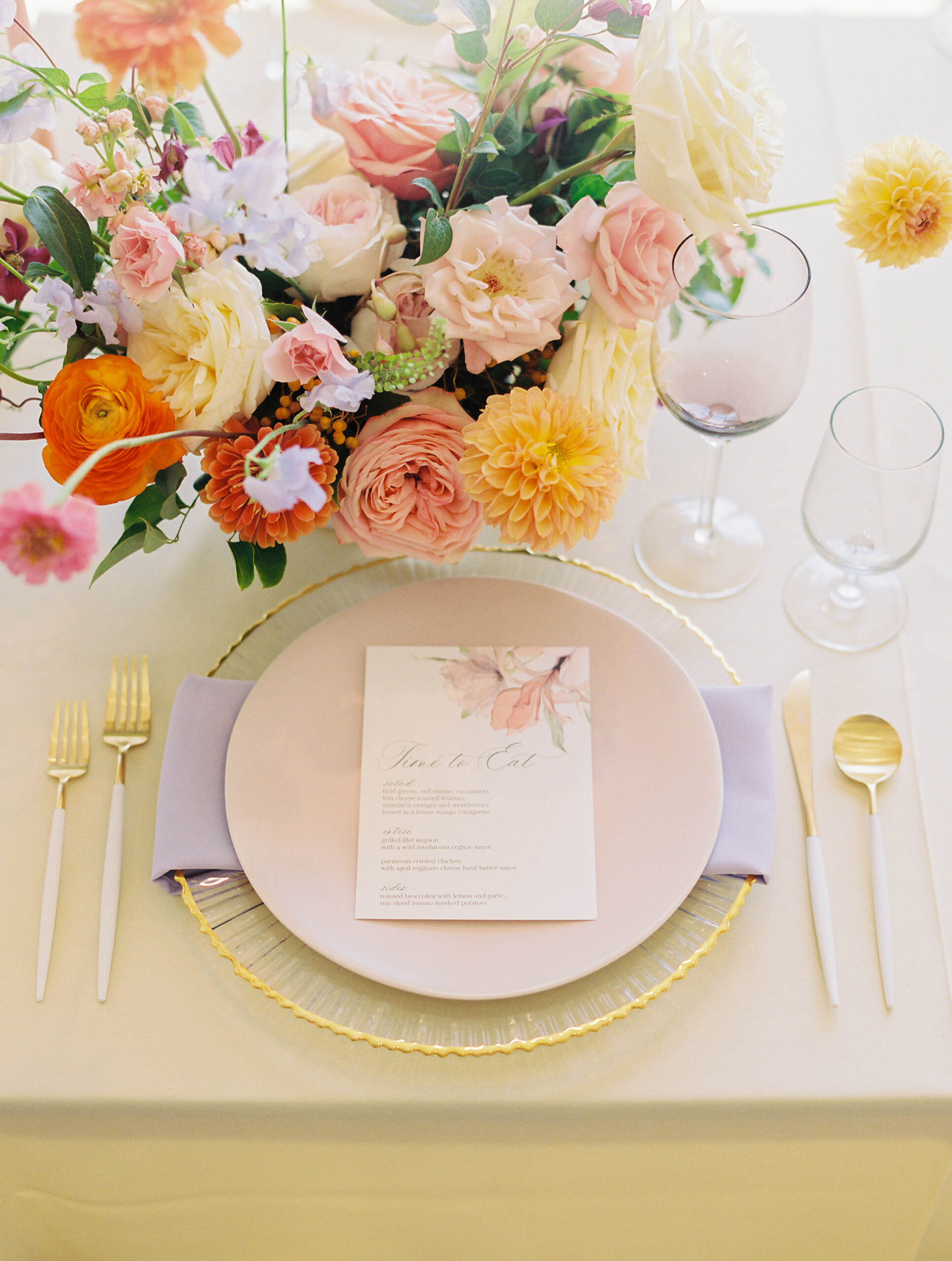 wedding reception table place setting with colorful floral arrangement
